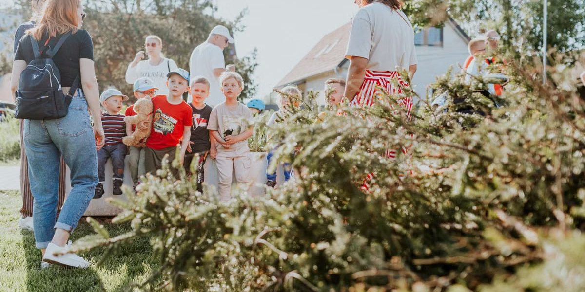 Children and adults participating in an outdoor educational activity surrounded by nature.