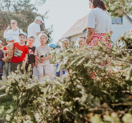 Children and adults participating in an outdoor educational activity surrounded by nature.